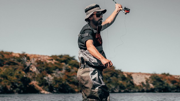 A man fishing in water, casting a line and wearing waders with the blog title as a text overlay