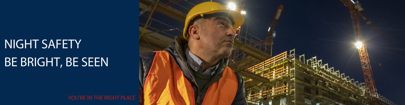  An image of a man on a construction site at night, wearing high visibility clothing